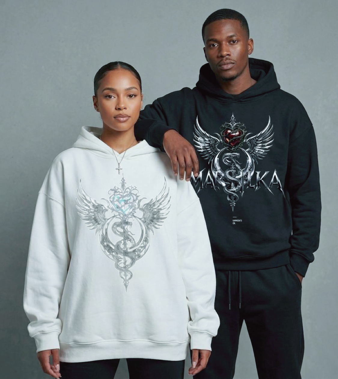 Two models in the chrome winged-serpent MARSILKA hoodies, studio shot